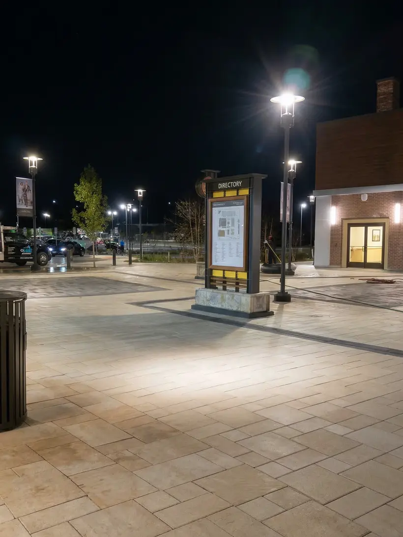 Plaza at night with directional totem and light posts