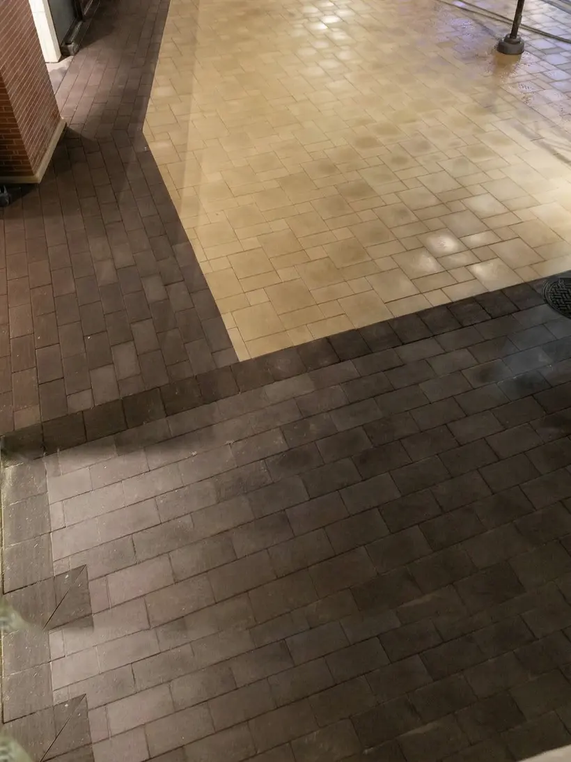 Wet paver walkway at night with planters