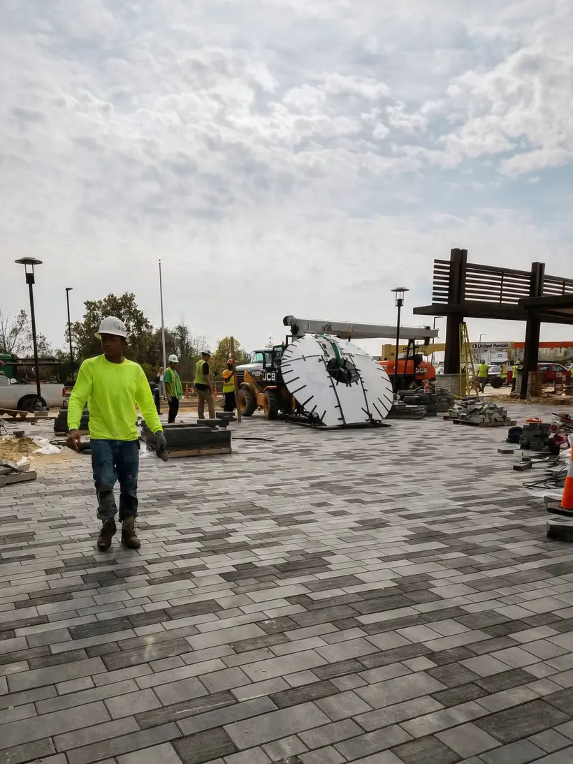 Worker crossing a plaza with stone discs