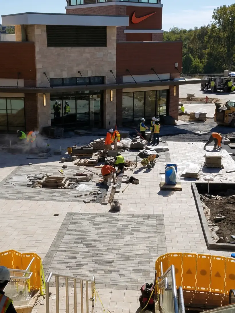 Crew paving next to a retail building